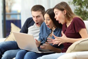 Cyber Week: drei Freunde erstaunt vor dem Computer